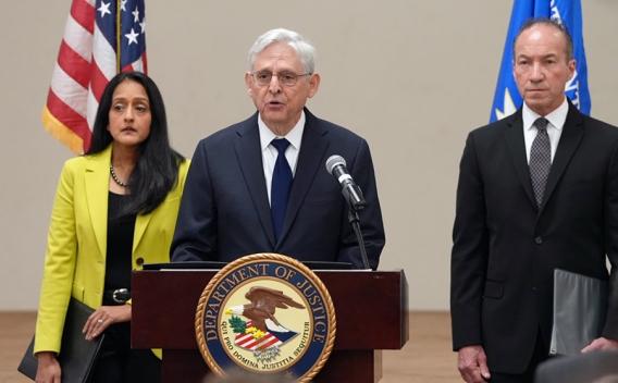 Attorney General Merrick B. Garland delivers remarks from a podium at the Herby Ham Activity Center in Uvalde, Texas. To the left is Associate Attorney General Vanita Gupta and to the right is COPS Director Hugh Clements, Jr.