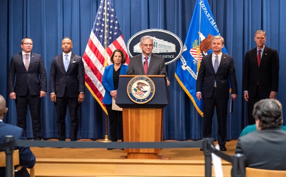 Attorney General Merrick B. Garland delivers remarks from a podium bearing the Department of Justice Seal.