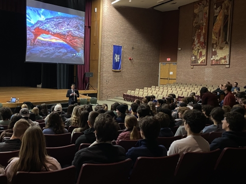 An Assistant U.S. Attorney giving a HEAT presentation to students in a high school auditorium